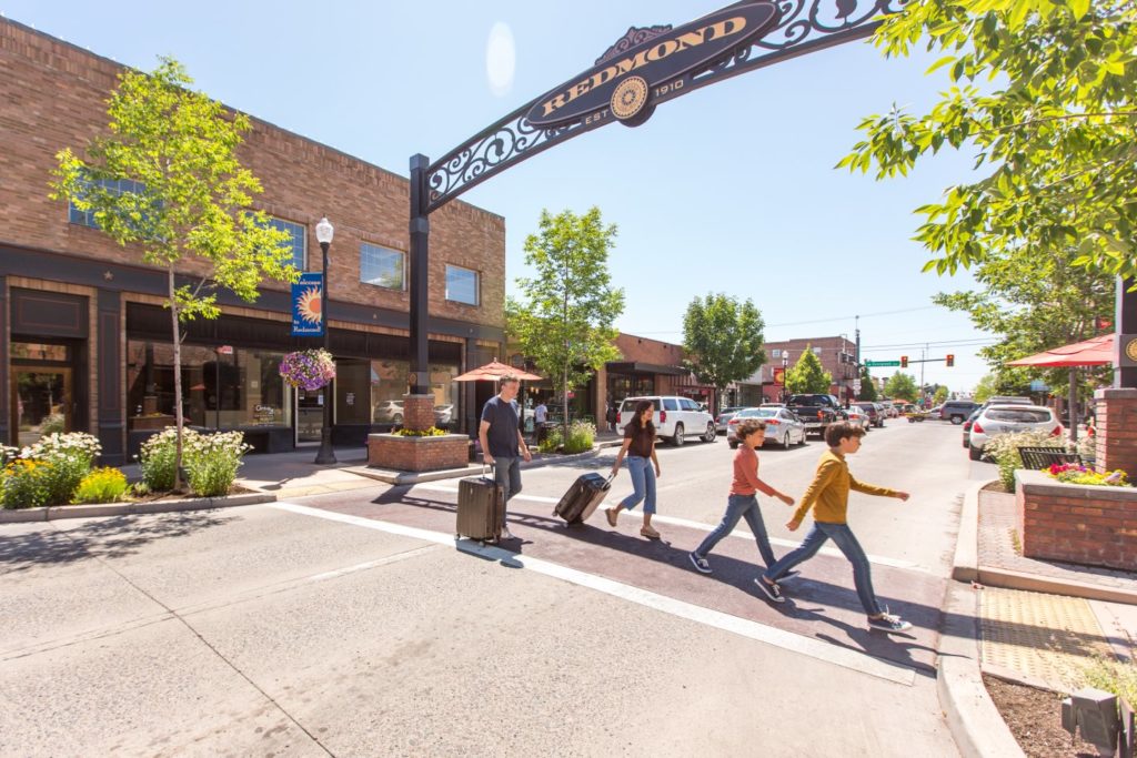 redmond A family walks through downtown Remond in Central Oregon with their luggage