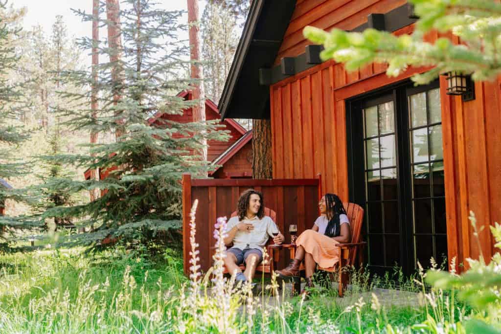2021-06-21-VCO-Sisters-183-large Two people enjoy wine on the patio of a cabin at FivePine Lodge in Sisters in Central Oregon
