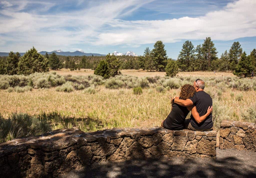 steve-heinrichs-photography-68-large couple relaxing outside at a park, taking in the view of the three sisters mountains
