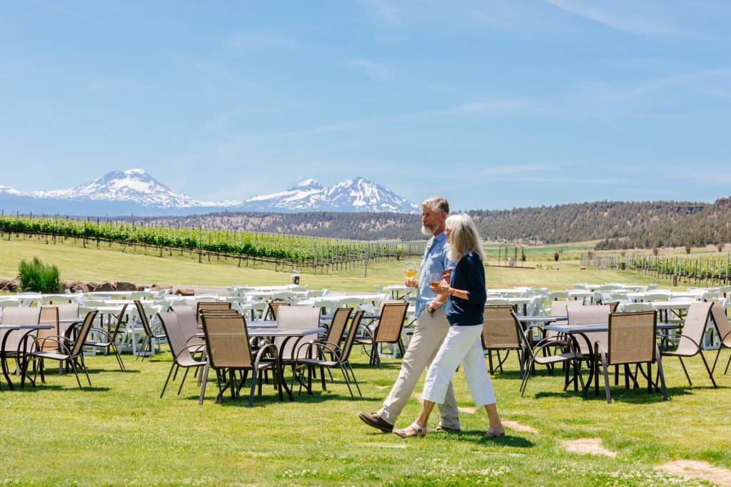 Faith-Hope-Charity-Vineyards-1-large a couple walking at a vineyard with a view of the 3 sisters