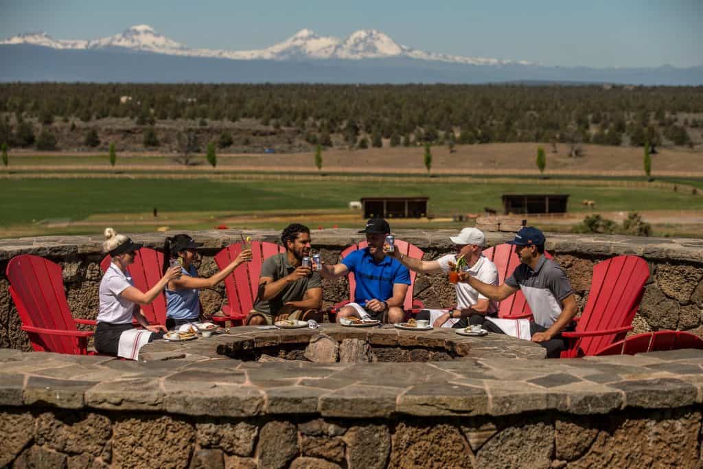 steve heinrichs photography-75-large (1) Group of people sitting in adirondack chairs toasting each other with beers at Brasada Ranch near Prineville, Oregon