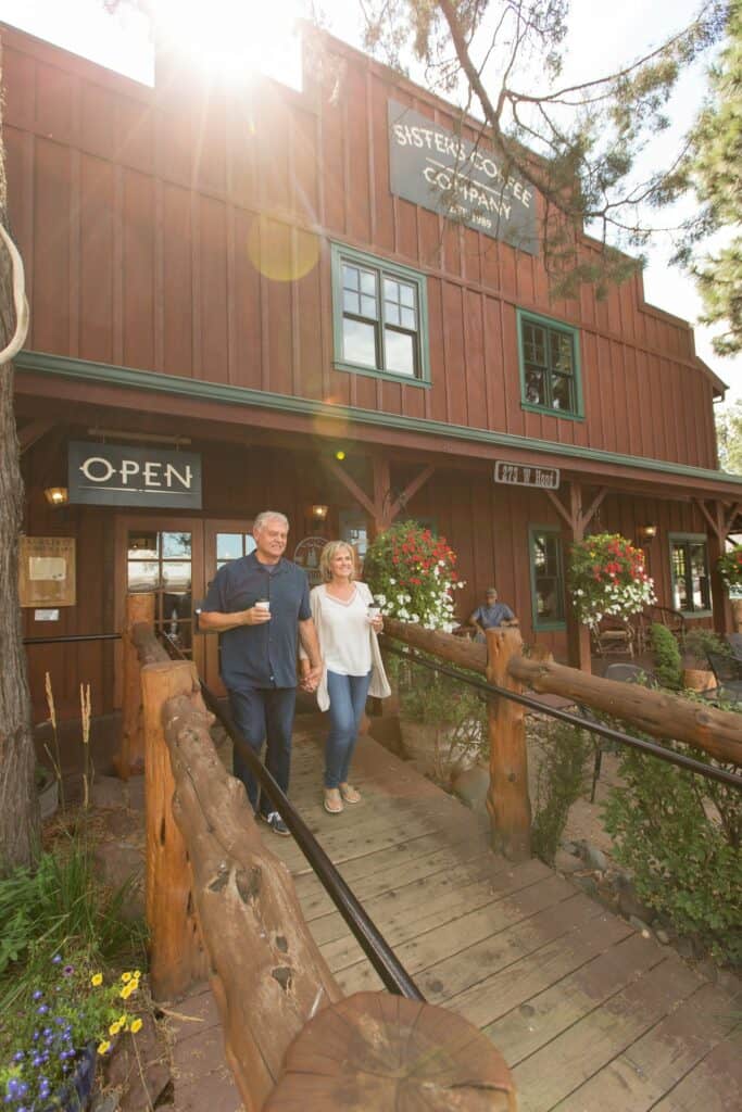 bend-oregon-lifestyle-photography-by-steve-heinrichs_-52-large older couple happily walking out of the coffee shop, drinks in hand.