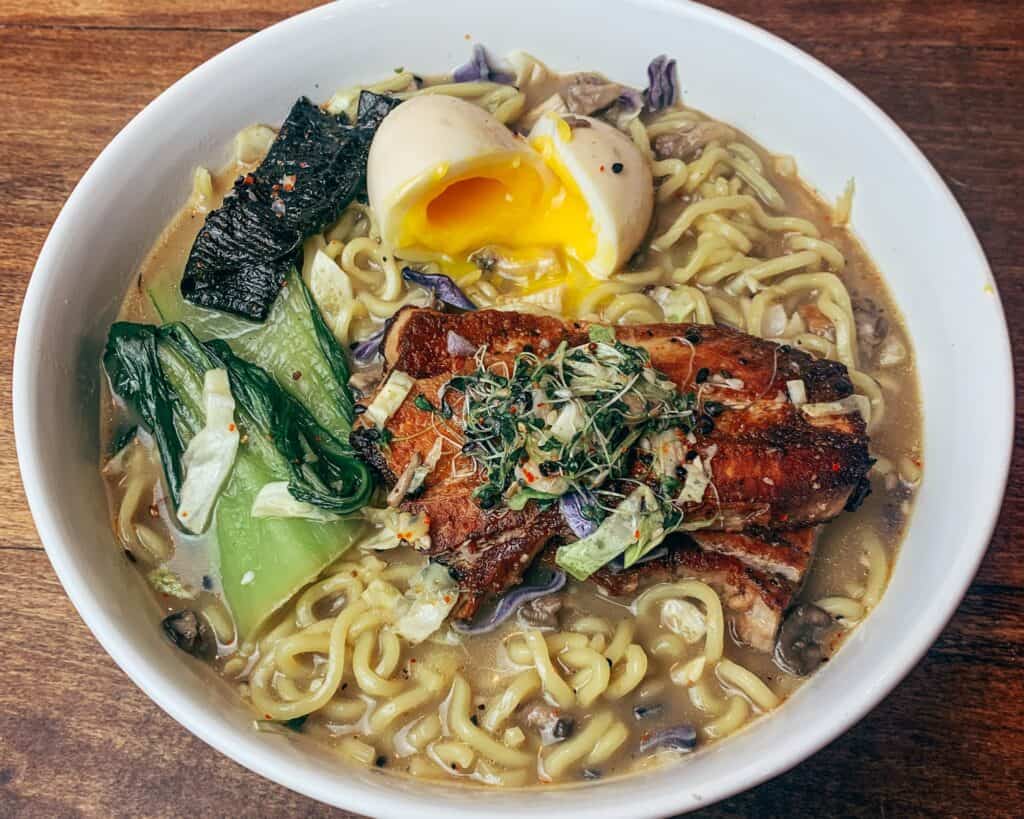 Crowd-Riff---Winter-1-large a big bowl of ramen noodles with a piece of salmon and a soft-boiled egg