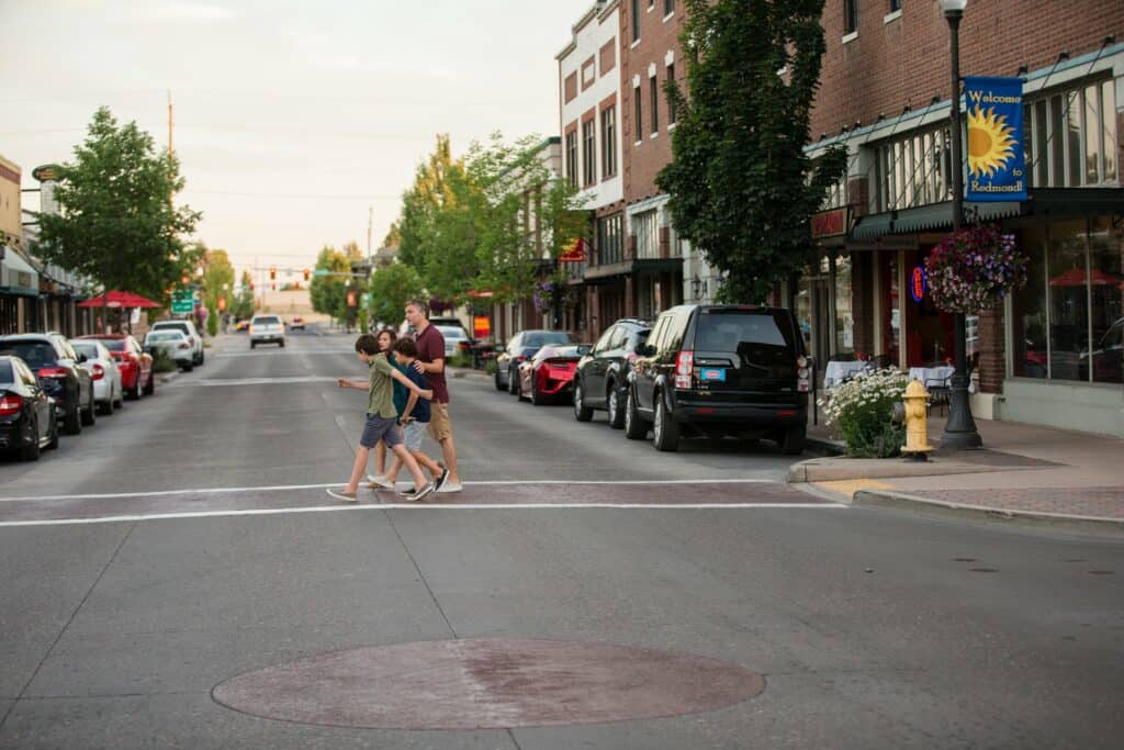 outdoor-adventure-travel-photography-by-steve-heinrichs_-52-large a family of 4 walking across the street in downtown Redmond, OR