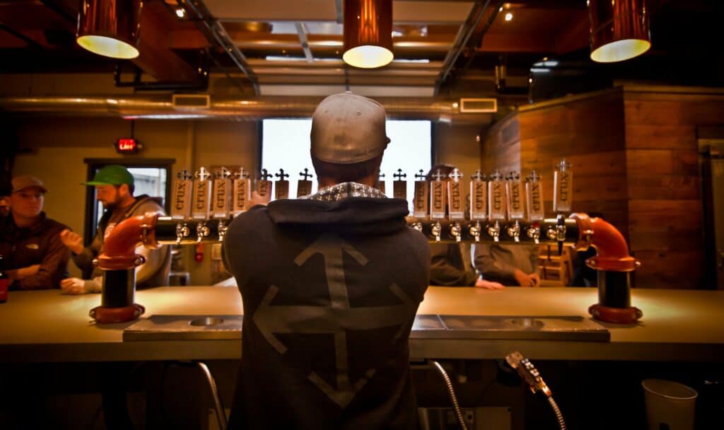 Bartender pours beers from tap at Crux Fermentation Project in Bend, Oregon