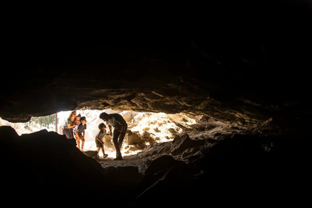 Family of five walks into the Redmond Caves in Redmond, Oregon