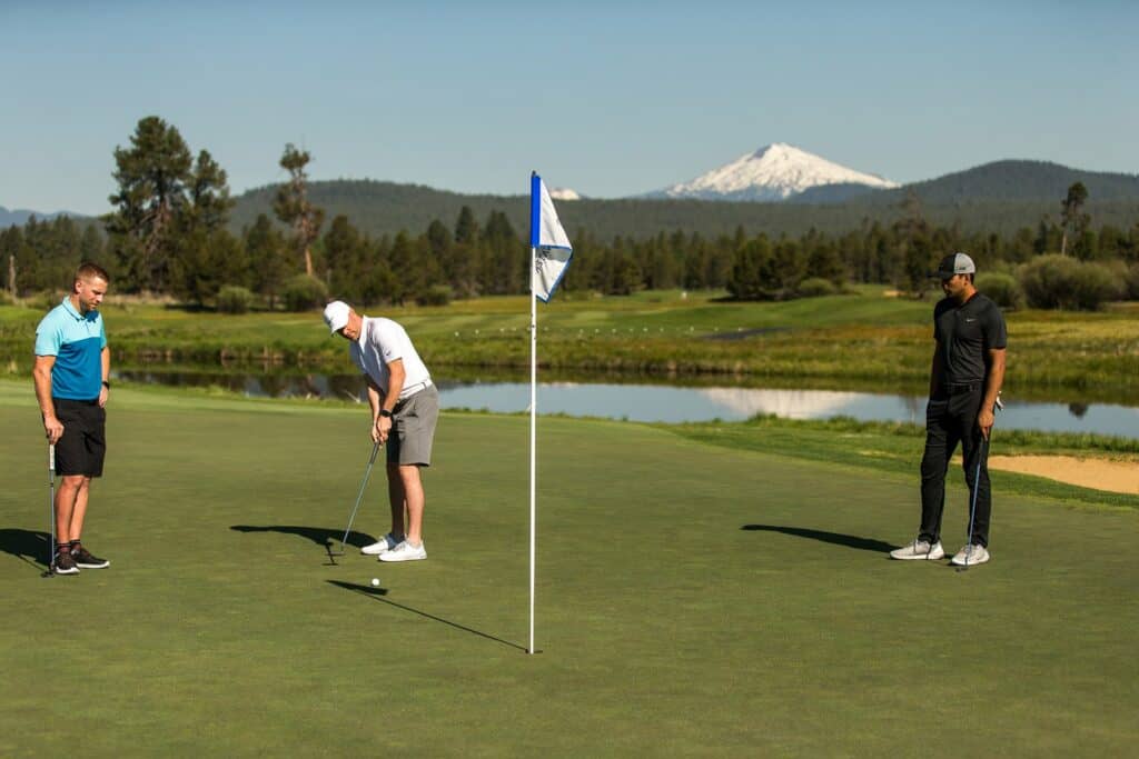 Three men on the putting green at Crosswater in Sunriver, Oregon