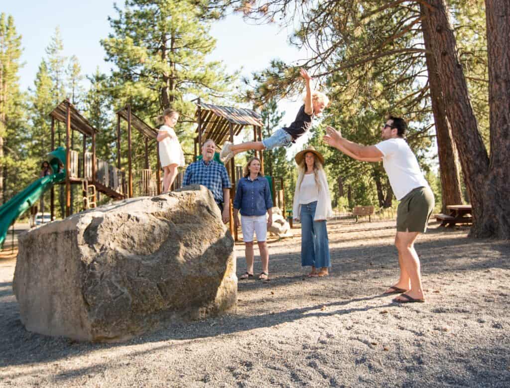 Son jumps from rock into father’s arms at playground in Sunriver, Oregon