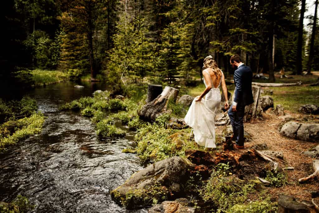 PaulinaWedding a couple walk along the bank of the river, she is a beautiful lace wedding dress and he, in a fitted suit