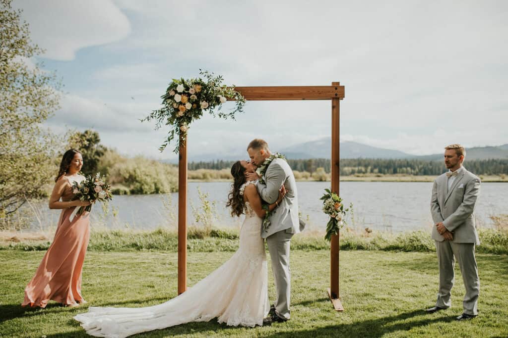 m and j teasers-14 (1) a couple tying the knot outside on the edge of river with the Three Sisters Mountains in view at Black Butte Ranch