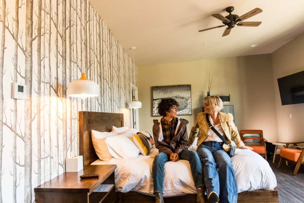 steve heinrichs photography-94-large Two women sit on bed at Ski Inn in Sisters, Oregon.