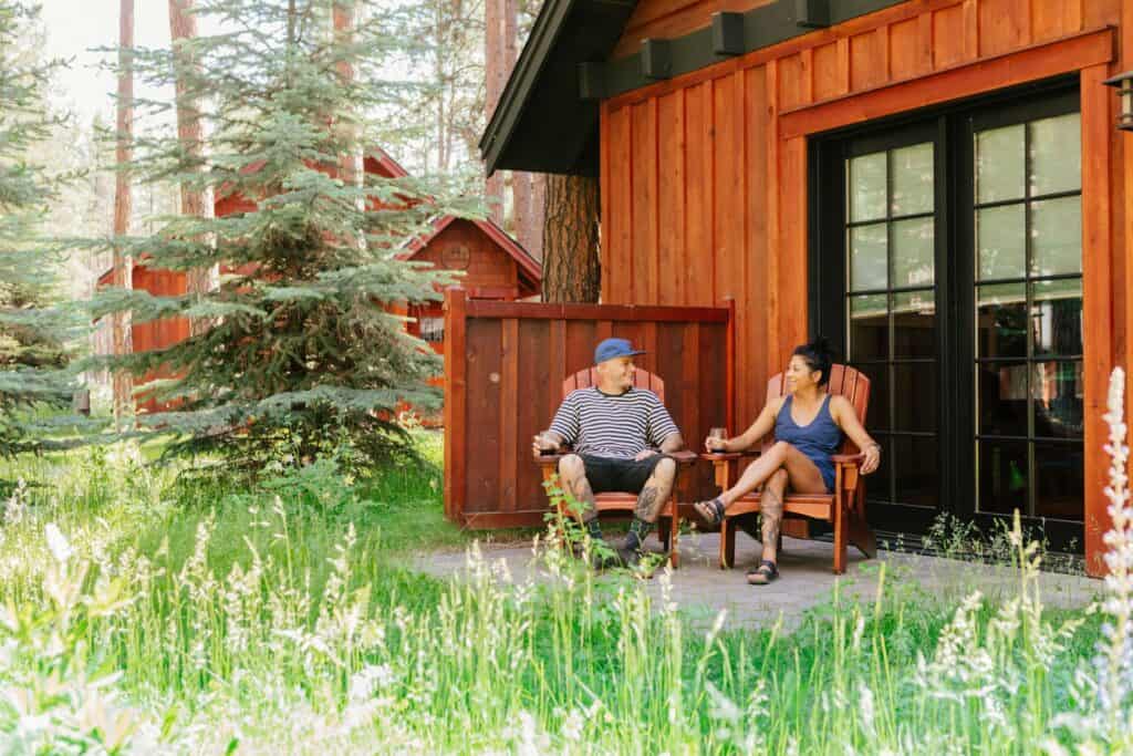 2021-06-21-VCO-Sisters-179-large Two people sit on a patio outside of a cabin at FivePine Lodge in Central Oregon