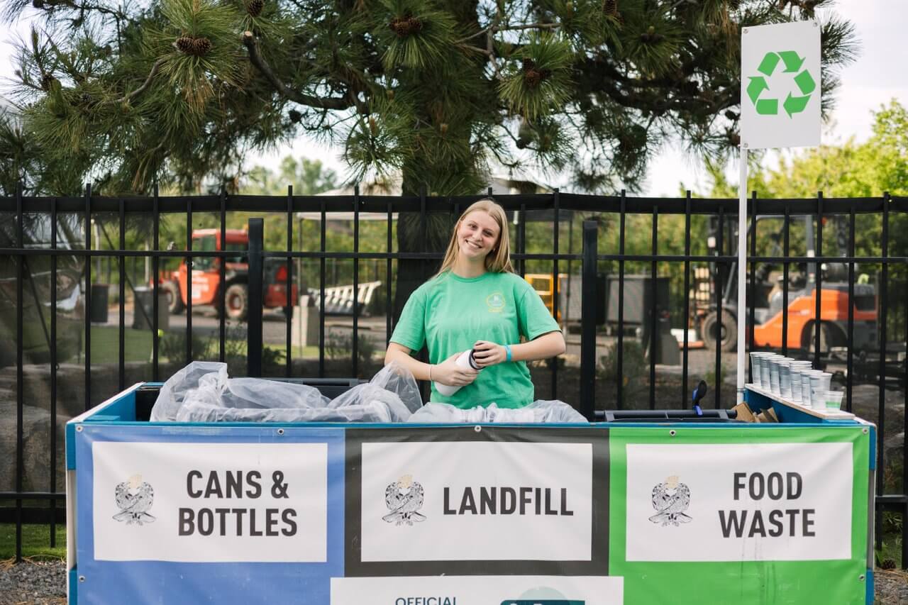 An employee at Hayden Homes Amphitheater helps guests separate their trash and recycle An employee at Hayden Homes Amphitheater helps guests separate their trash and recycle