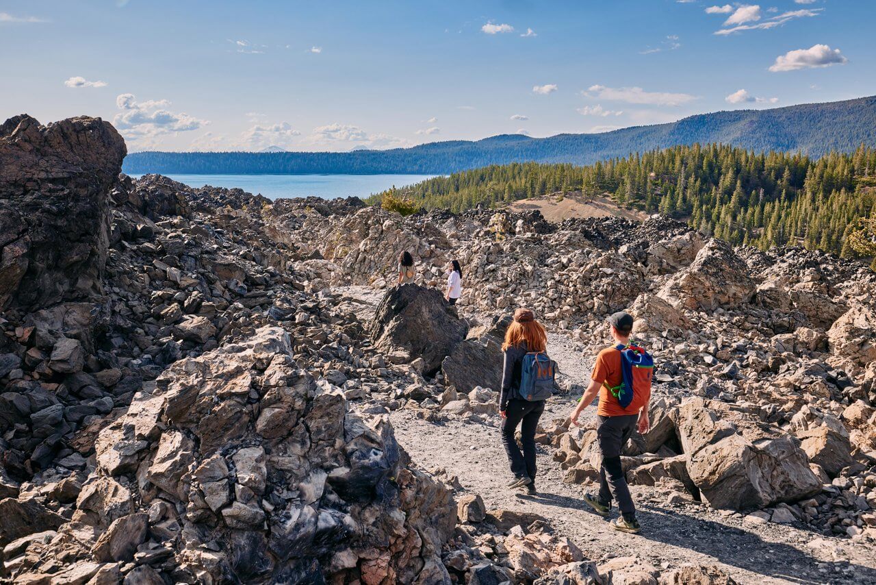 Group of hikers on the Big Obsidian Flow trail in the Newberry National Volcanic Monument near La Pine, Oregon